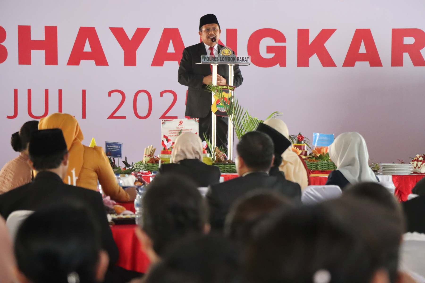 Lombok Barat, NTB – Kepolisian Republik Indonesia (Polri) merayakan ulang tahunnya yang ke-79 pada 1 Juli 2025. Di Lombok Barat, peringatan Hari Bhayangkara kali ini selain dengan menggelar upacara, juga ditandai dengan acara tasyakuran yang penuh makna. Menegaskan kembali komitmen Polri untuk terus meningkatkan kualitas pelayanan kepada masyarakat. Pada Selasa (1/7/2025), suasana di bencingah kantor Bupati Lombok Barat tampak semarak dengan kehadiran para pejabat dan tokoh masyarakat. Acara Tasyakuran Hari Bhayangkara ke-79 ini digelar di Jalan Soekarno-Hatta, Kelurahan Dasan Geres, Kecamatan Gerung, Kabupaten Lombok Barat, menjadi momentum penting. Untuk mempererat sinergitas antara Polri, TNI, pemerintah daerah, dan seluruh elemen masyarakat. Meningkatkan Pelayanan dan Memperkuat Sinergi Dalam sambutannya yang penuh semangat, Kapolres Lombok Barat, AKBP Yasmara Harahap, S.I.K., menyampaikan bahwa Hari Bhayangkara ke-79 mengusung tema ‘Polri untuk Masyarakat’. Menurutnya, tema ini bukan sekadar slogan, melainkan sebuah amanah untuk terus berbenah. "Dalam rangka Hari Bhayangkara ke-79 tahun 2025 dengan tema Polri Untuk Masyarakat, tentunya kita harus meningkatkan kualitas diri sebagai insan Bhayangkara. Untuk melaksanakan pelayanan maksimal kepada masyarakat," ujar AKBP Yasmara. Ia menekankan pentingnya introspeksi diri dan peningkatan kinerja untuk memberikan pelayanan terbaik. "Polri tegak berdiri dan berkomitmen untuk menjadi lebih modern dan terpercaya," tambahnya. Menurut Kapolres, semua upaya ini bertujuan utama untuk menjaga stabilitas keamanan dan ketertiban masyarakat (kamtibmas) di Provinsi NTB agar tetap kondusif. Ia juga menjelaskan bahwa rangkaian kegiatan dalam rangka Hari Bhayangkara di Polres Lombok Barat sudah dimulai sejak awal Juni. Dengan berbagai kegiatan yang menyentuh langsung masyarakat. AKBP Yasmara Harahap juga menyampaikan rasa terima kasihnya kepada semua pihak yang telah mendukung tugas-tugas Polri. "Terima kasih kepada Bapak Bupati yang telah mendukung tugas-tugas kamtibmas. Tidak mungkin kami berjalan sendiri tanpa dukungan dari Pemda dan seluruh elemen masyarakat," tegasnya. Kolaborasi Pemerintah dan Polri untuk Pelayanan Optimal Senada dengan Kapolres, Bupati Lombok Barat, H. Lalu Ahmad Zaini, S. Si., M.T., juga memberikan apresiasi setinggi-tingginya kepada jajaran kepolisian. Dalam pernyataannya, Bupati mengucapkan selamat Hari Bhayangkara dan menekankan pentingnya sinergi antara pemerintah daerah dan Polri. "Atas nama Pemerintah Kabupaten Lombok Barat, kami menyampaikan dirgahayu Kepolisian," kata Bupati Lalu Ahmad Zaini. "Sinergitas dan kolaborasi akan terus kita tingkatkan agar pelayanan kepada masyarakat akan terus dapat dioptimalkan,” imbuhnya. Pernyataan ini menunjukkan komitmen kuat dari pemerintah daerah untuk terus bekerja sama dengan Polri demi kesejahteraan dan keamanan masyarakat Lombok Barat. Momen Kebersamaan dan Apresiasi Setelah sambutan, acara dilanjutkan dengan momen simbolis pemotongan kue dan tumpeng. Kapolres Lombok Barat bersama Ibu Ketua Bhayangkari, Bupati Lombok Barat, perwakilan Dandim 1606, Wakil Bupati, Sekda, dan Ketua DPRD secara bersama-sama melakukan pemotongan tumpeng, melambangkan kebersamaan dan rasa syukur. Kemeriahan acara juga terasa saat pembacaan dan penyerahan hadiah bagi para pemenang lomba-lomba yang diselenggarakan dalam rangka memeriahkan Hari Bhayangkara ke-79. Berbagai lomba tersebut tidak hanya menjadi ajang silaturahmi, tetapi juga menunjukkan partisipasi aktif masyarakat dalam perayaan hari jadi korps Bhayangkara. Peringatan Hari Bhayangkara ke-79 ini menjadi momentum refleksi bagi seluruh jajaran Polres Lombok Barat untuk terus berbenah dan meningkatkan kualitas diri. Turut hadir pula dalam acara ini, Ketua Cabang Bhayangkari Lombok Barat, Ny. Citra Yasmara, bersama jajaran pengurus. Serta perwakilan dari Kodim 1606 Mataram, Letkol Inf. Abdul Haris S.H. M.H. Selain itu, hadir pula Wakil Bupati Lombok Barat, Hj. Nurul Adha, S.THI, Sekda Kabupaten Lombok Barat, H. Ilham S.Pd M.Pd., Ketua DPRD Kabupaten Lombok Barat, Lalu Ivan Indaryadi, serta perwakilan dari Pengadilan Negeri Mataram dan Kejaksaan Negeri Mataram. Kehadiran para pimpinan OPD, tokoh agama, tokoh masyarakat, dan tokoh adat menunjukkan soliditas dukungan terhadap tugas-tugas kepolisian.